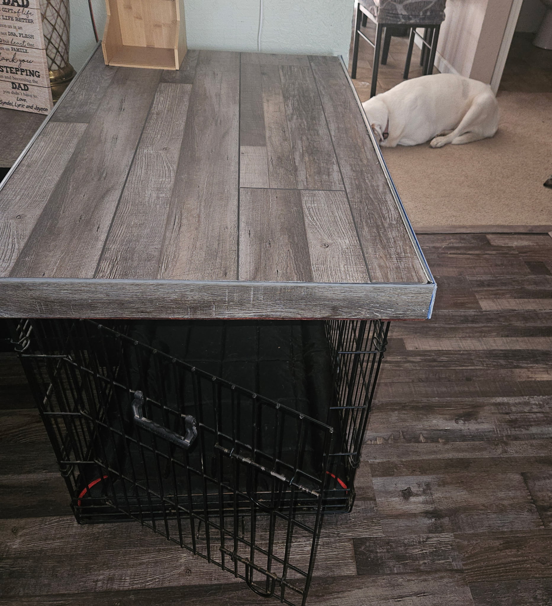 Custom dog cage shelf with finished wood top built over a pet crate